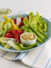 Crudite with Hummus on green plate over towel — Stock Photo