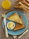 Toast triangles with butter and orange juice — Stock Photo