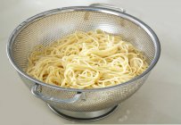 Cooked spaghetti in metal strainer — Stock Photo