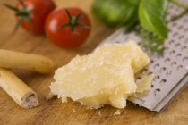 Parmesan with grater on wooden surface — Stock Photo