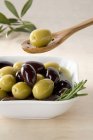 Зеленые и черные оливки в миске — стоковое фото
