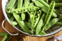 Fresh green peas in colander — Stock Photo