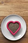 Vista superior de sementes de Chia em forma de coração tigela na superfície de madeira — Fotografia de Stock