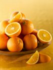 Ripe Oranges in wooden bowl — Stock Photo