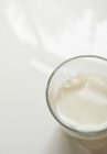 Стакан молока на белой поверхности — стоковое фото