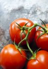 Quatro tomates maduros de videira — Fotografia de Stock