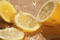 Limão fatiado com salpicos de água — Fotografia de Stock
