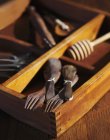 Vista de cerca de cucharas y tenedores de madera viejos con herramientas viejas en una caja de madera - foto de stock