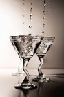 Martinis gotejando e salpicando em copos — Fotografia de Stock