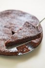 Schokoladenkuchen mit Stück auf Kuchenscheibe — Stockfoto