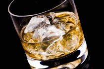 Copa de whisky con cubitos de hielo - foto de stock