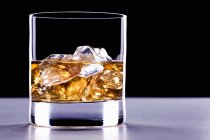 Bicchiere di whisky con cubetti di ghiaccio — Foto stock