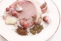 Raw pork chop with garlic and spices — Stock Photo