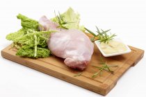 Ingredients for rabbit leg with savoy cabbage on wooden desk — Stock Photo