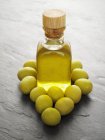 Olivenöl und grüne Oliven — Stockfoto