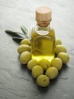 Оливковое масло и зеленые оливки — стоковое фото