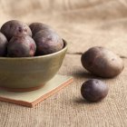 Batatas vermelhas cruas em tigela — Fotografia de Stock