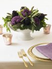 Closeup view of laid table with purple artichokes and cauliflower — Stock Photo
