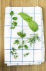 Top view of various fresh herbs on a tea towel — Stock Photo