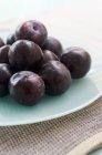 Fresh ripe plums in plate — Stock Photo
