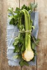 Half a celeriac bulb on towel over wooden surface — Stock Photo