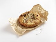 A mini focaccia with garlic and herbs on white surface — Stock Photo