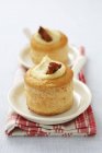 Vol au vents filled with hummus and dried tomatoes on white plate over towel — Stock Photo