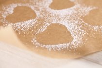 Vue rapprochée des empreintes en forme de coeur dans le sucre glace sur parchemin — Photo de stock