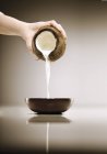 Versare a mano il latte di cocco — Foto stock