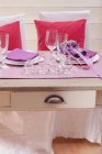 Uma mesa com duas configurações de lugar, presentes e vidros para o dia dos namorados — Fotografia de Stock