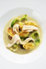 Chestnut and Brussels sprout stew with potato gnocchi and pheasant breast on white plate — Stock Photo