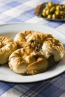 Puff pastry filled with chicken, aubergines, olives and raisins on white plate over towel — Stock Photo