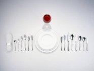 Верхний вид тарелок со столовыми приборами, салфеткой и бокалом красного вина — стоковое фото