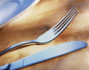 Closeup view of knife and fork on wooden surface — Stock Photo