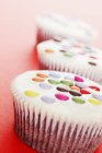 Cupcakes decorated with colored chocolate beans — Stock Photo