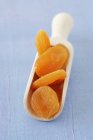 Dried apricots in wooden scoop — Stock Photo