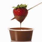 Крупним планом вид полуниці, зануреної в шоколадний соус — стокове фото