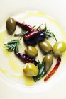 Oliven mit Rosmarin und Paprika in Olivenöl — Stockfoto