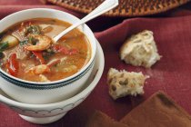Closeup view of shrimp and smoked oyster Chowder with pumpkin seed roll — Stock Photo
