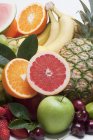 Various fresh whole and halved fruits — Stock Photo
