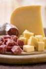 Cheese and salami on board — Stock Photo