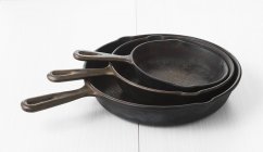 Closeup view of three iron pans in different sizes — Stock Photo