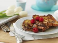 Closeup view of French toasts with raspberries — Stock Photo