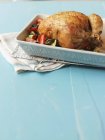 Whole roasted chicken in roasting tin — Stock Photo