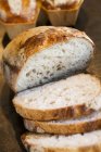 Parcialmente fatiado pão recém-assado — Fotografia de Stock