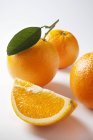 Ripe oranges with wedge — Stock Photo