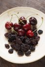 Тарелка свежей и сушеной вишни — стоковое фото