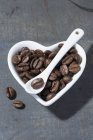 Coffee beans in heart-shaped bowl — Stock Photo