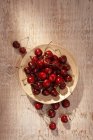 Wooden plate of red cherries — Stock Photo