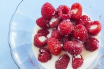 Raspberries with milk in bowl — Stock Photo